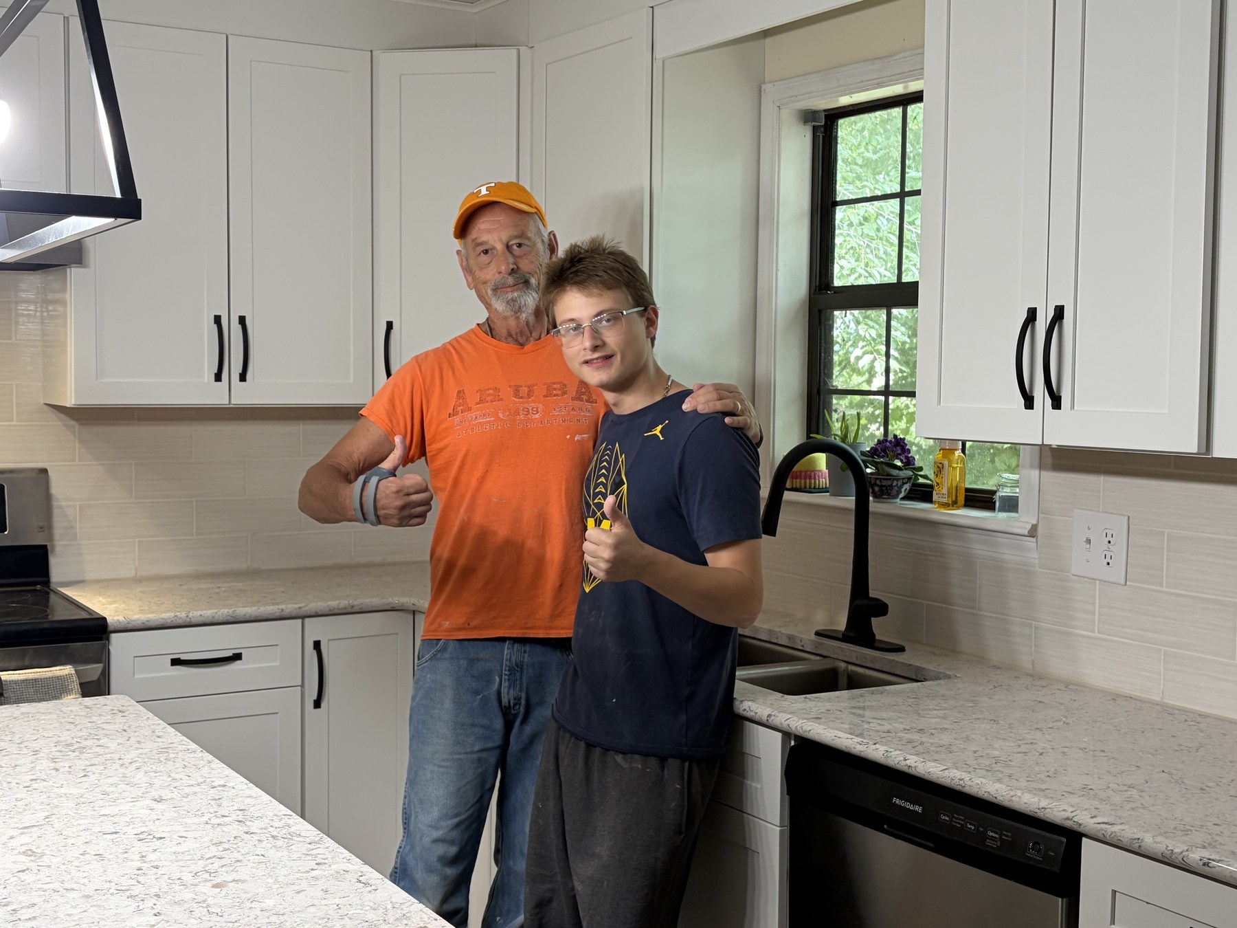 Brian and Tyler in a finished white shaker kitchen they remodeled, Manchester TN