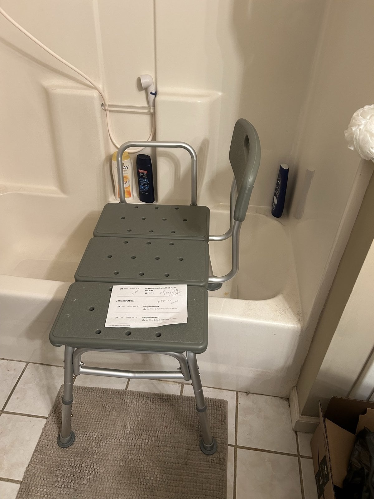 Old fiberglass tub surround with a transfer bench before accessible bathroom remodel